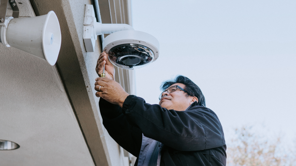 Security technician performing a camera installation, a small part of a security system update project. 