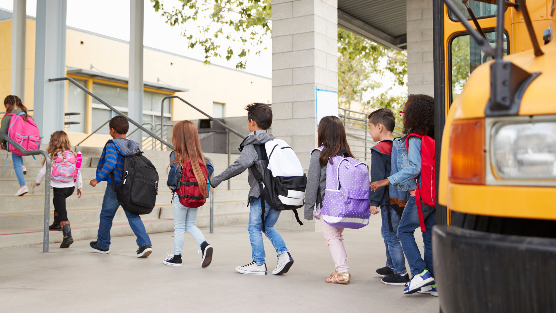 Elementary children walking to school entrance