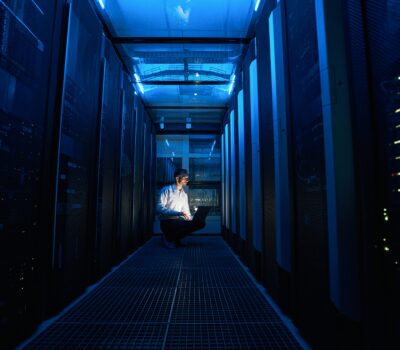 IT professional monitoring data-driven security in a modern server room to prevent downtime.